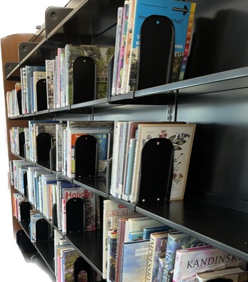 A close up to a library shelf with books on it.