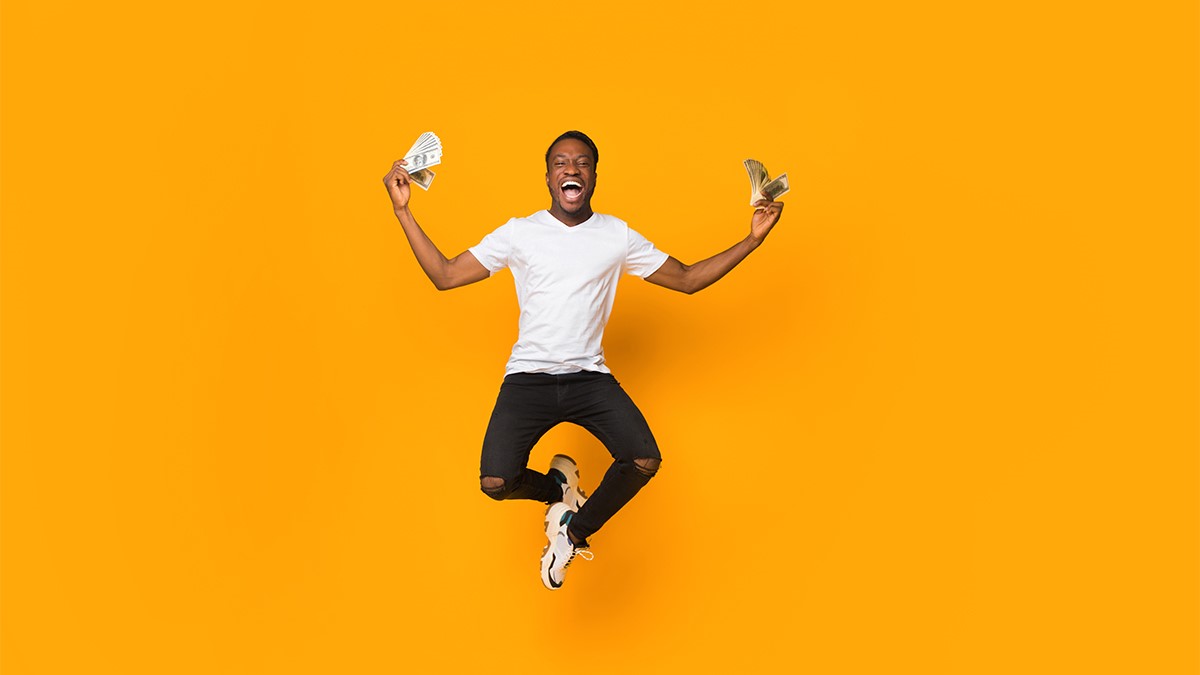 Person jumping happily with money in their hands