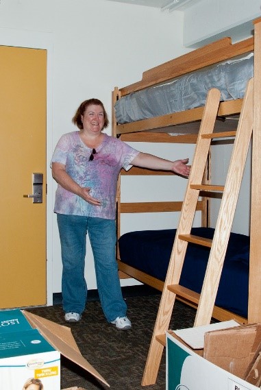 A person pointing to their made bed