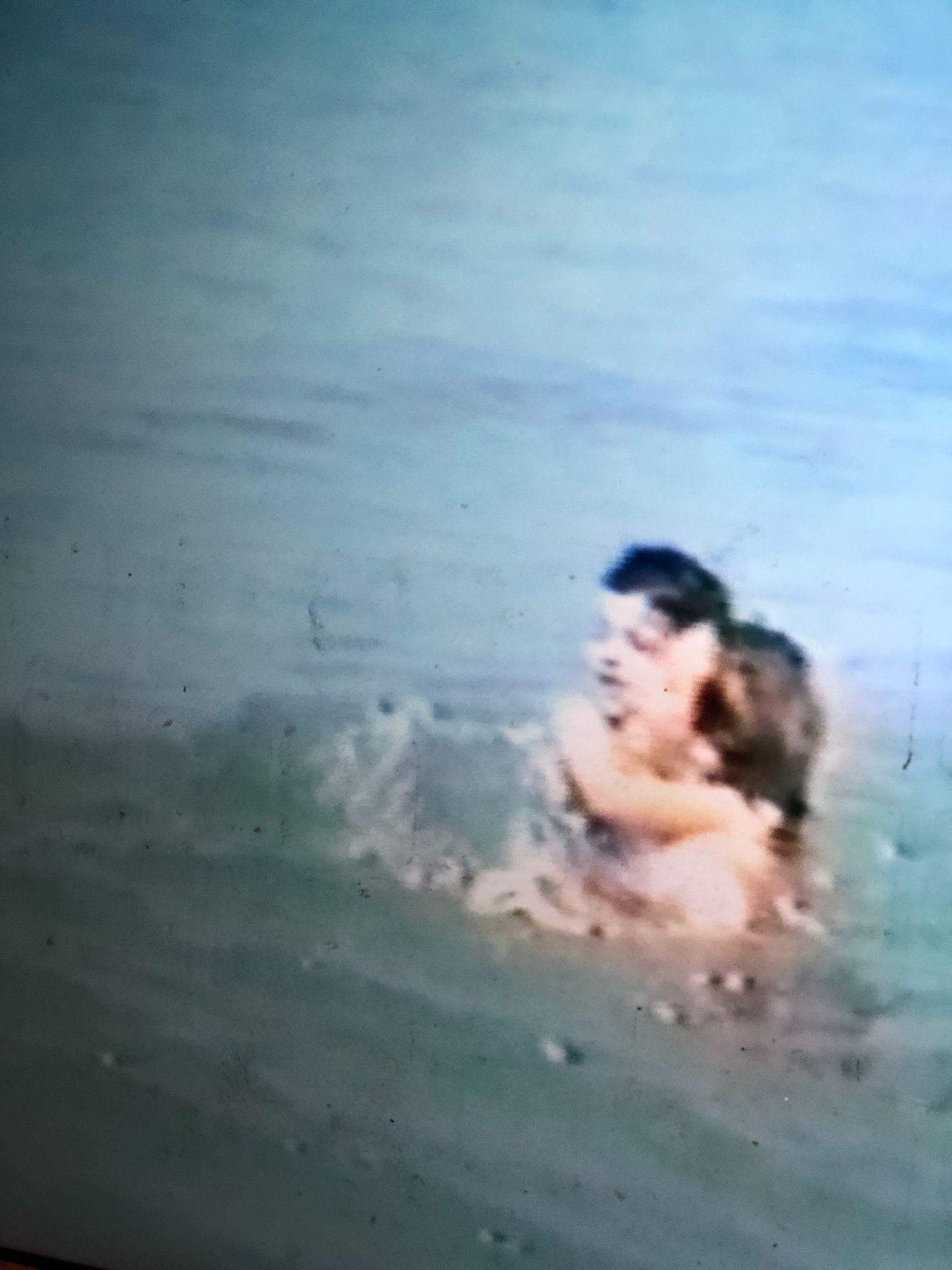 Home video still of the author as a child swimming in the Atlantic Ocean with her mother.