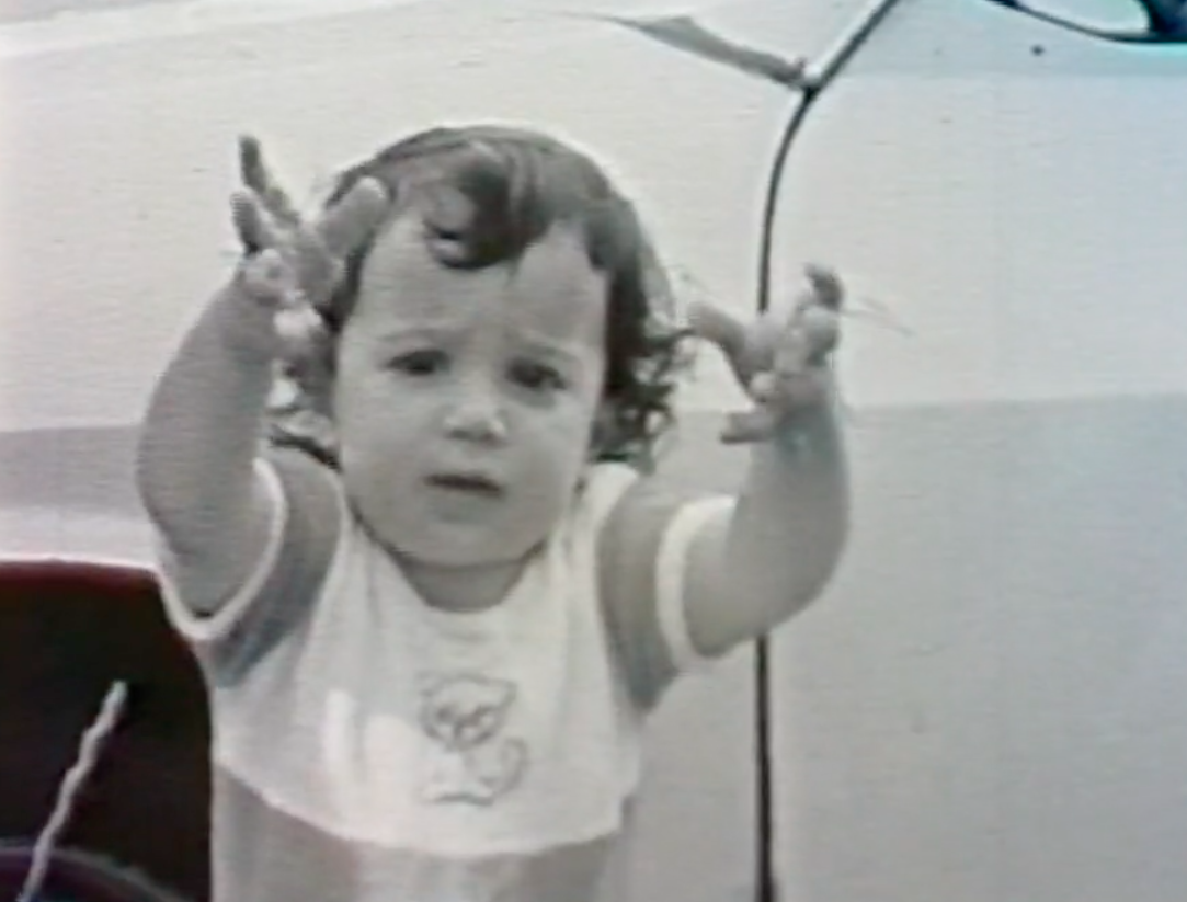 A black-and-white photo of the author as a child as she reaches toward the camera.