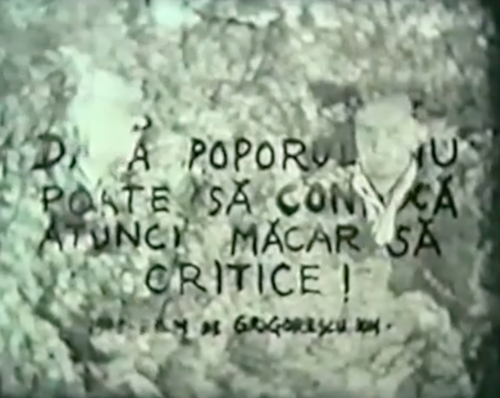 A faded film still of two men with handwritten Romanian text on top.