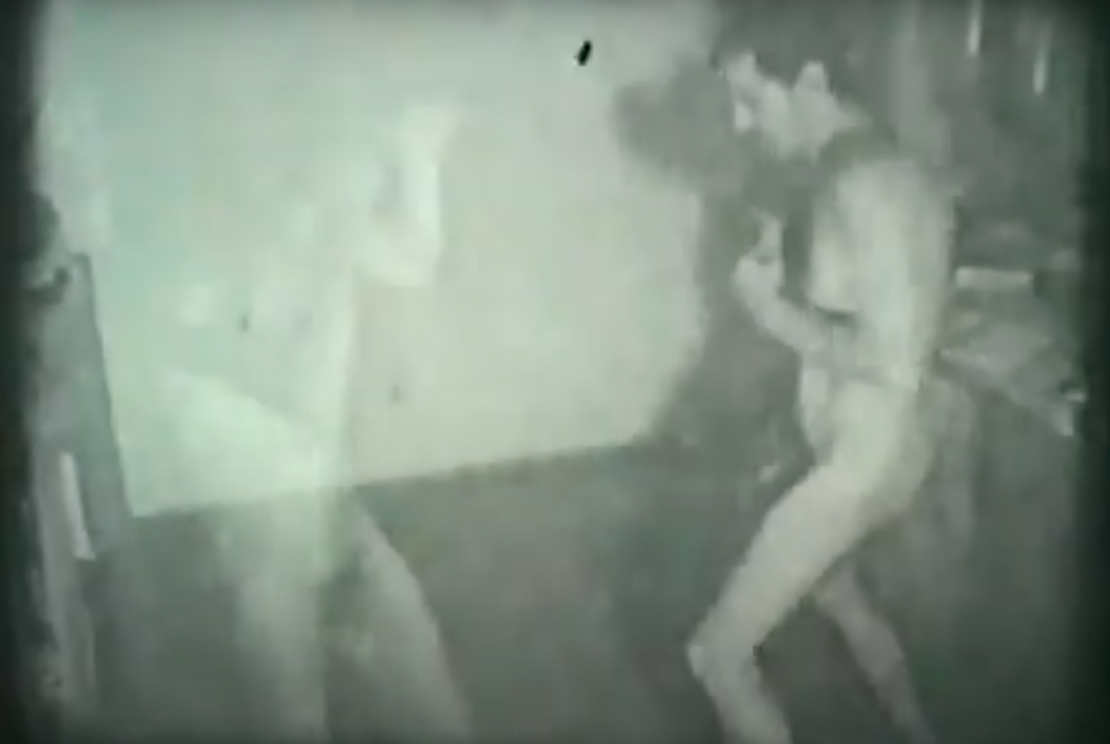 A film still of Ion Grigorescu and a duplicate of himself in the nude. Standing in the middle of the room and facing each other for a boxing match.