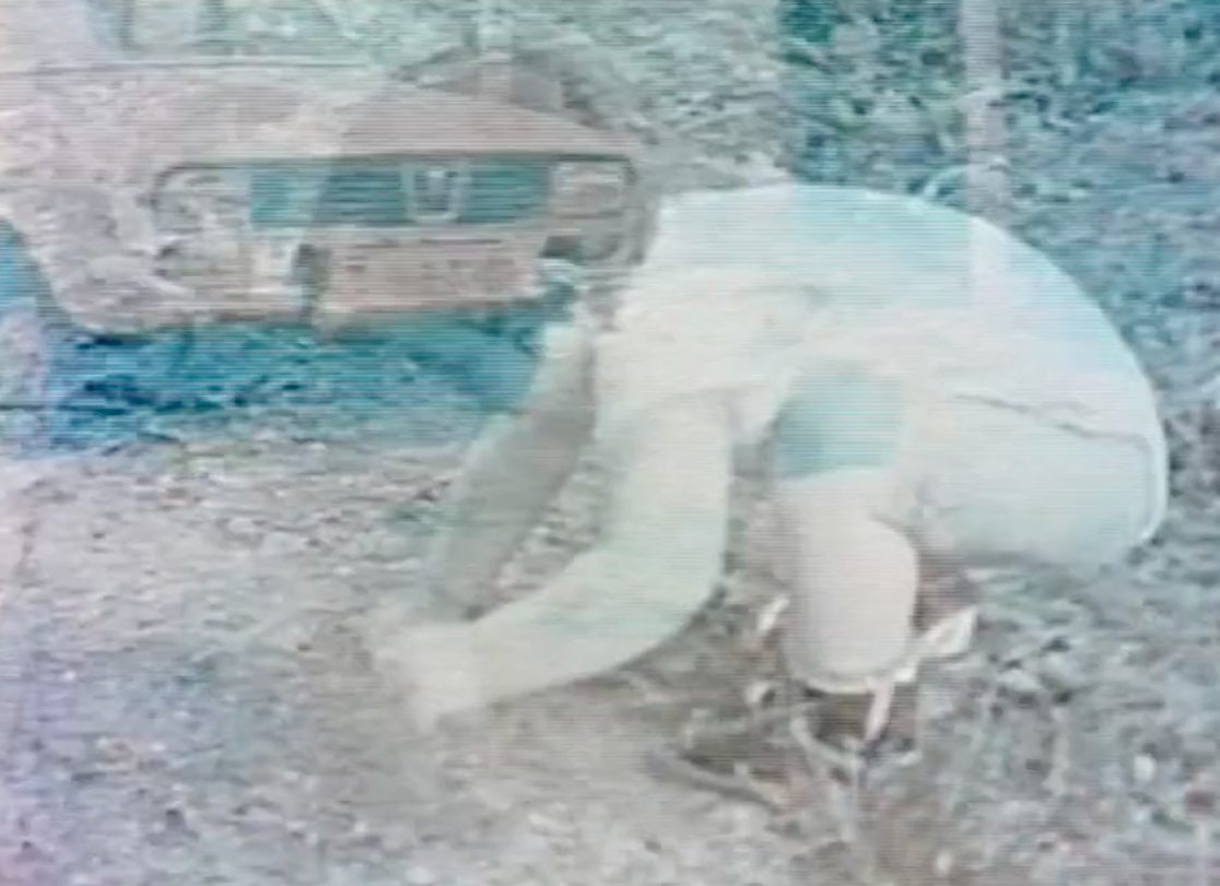 Black and white photo of the author as a child digging in the dirt. A car can be seen behind her.