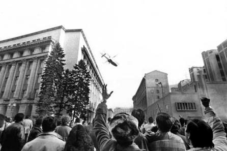 Black and white picture of dictator Nicolae Ceaușescu's helicopter leaving while a crowd watches.